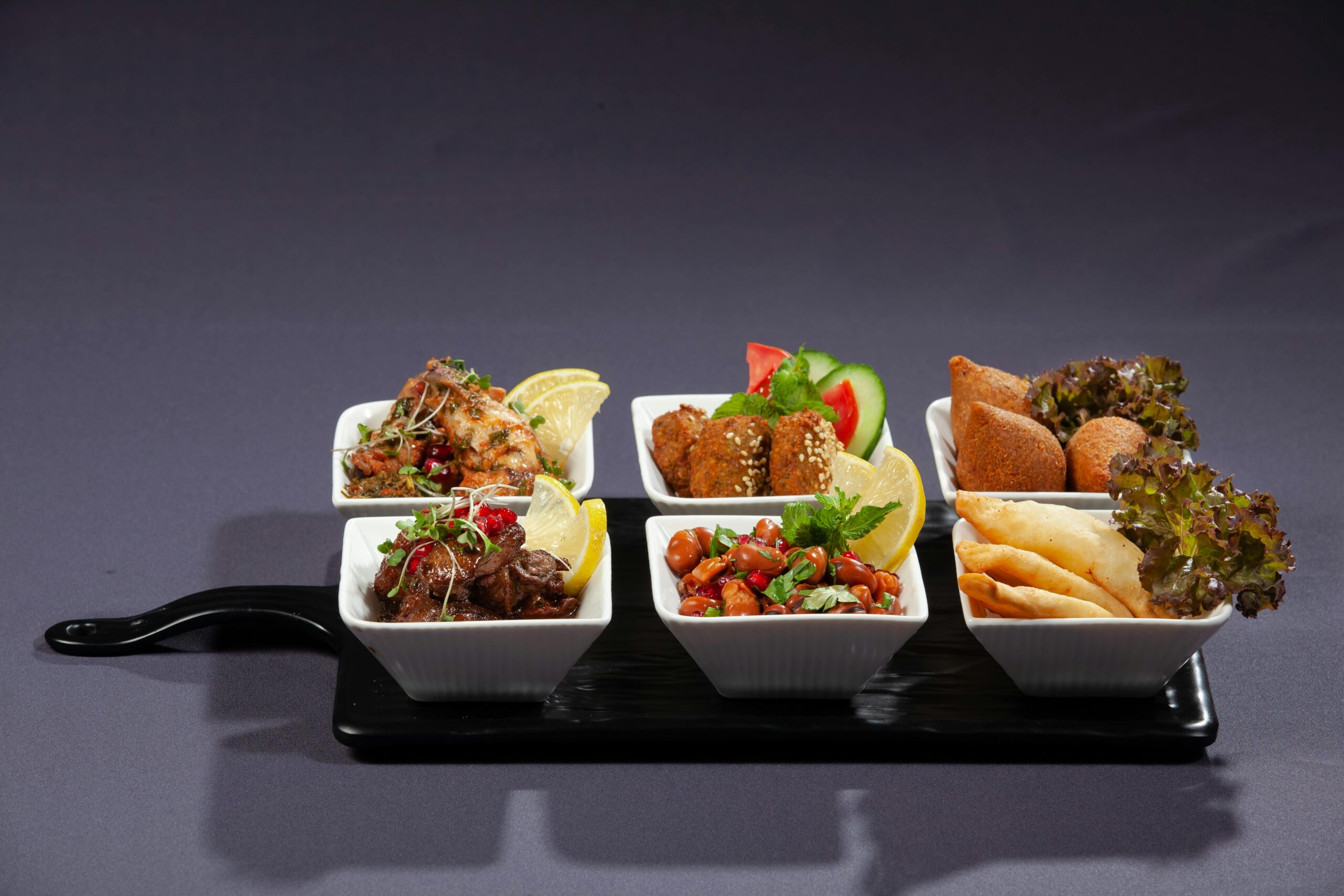 A vibrant selection of Middle Eastern appetizers served in elegant dishes, perfect for food photography enthusiasts.